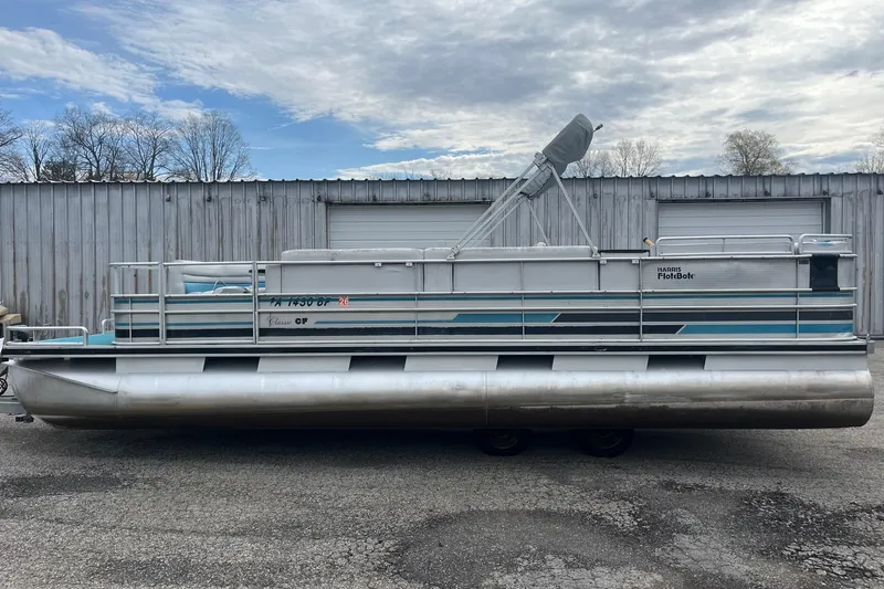 Slide: The Image of 1992 Harris FloteBote 240 Classic pontoon boat parked outdoors, overcast sky. - 3