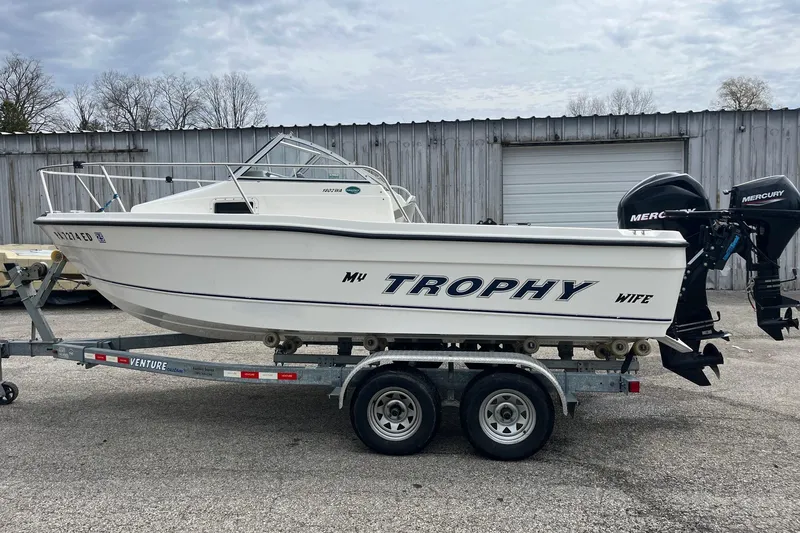 Slide: The Image of 2010 Trophy 1802 Walkaround boat on trailer, parked outdoors near a metal building. - 5