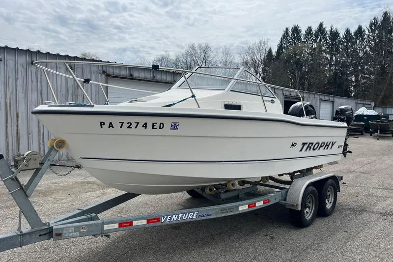 Slide: The Image of 2010 Trophy 1802 Walkaround boat on trailer, parked outdoors near storage units. - 6