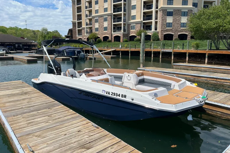 The Image of 2026 Starcraft SVX 211 OB boat docked at a marina, with modern buildings in the background. - 0