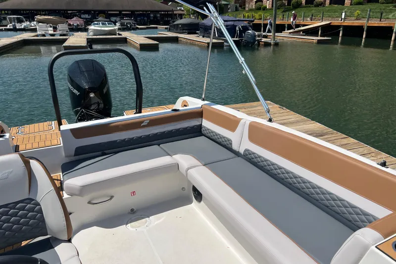 Slide: The Image of 2026 Starcraft SVX 211 OB boat interior with cushioned seating at a marina dock. - 12