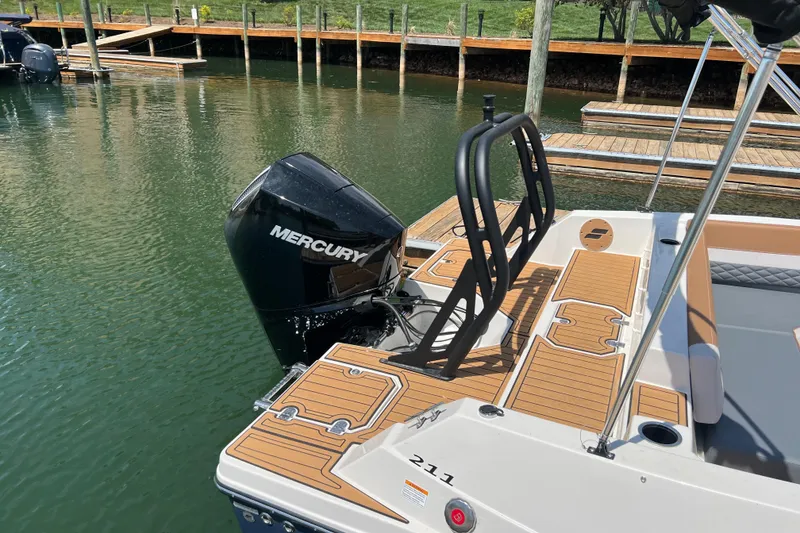Slide: The Image of 2026 Starcraft SVX 211 OB boat with Mercury outboard engine docked on calm water. - 2