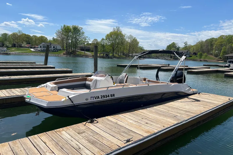 Slide: The Image of 2026 Starcraft SVX 211 OB boat docked on a serene lake under a clear blue sky. - 3
