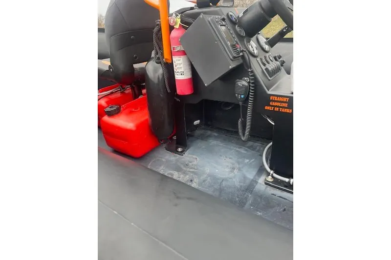 Slide: The Image of Interior of a 1997 Zodiac boat with fire extinguisher and red fuel tank. - 10