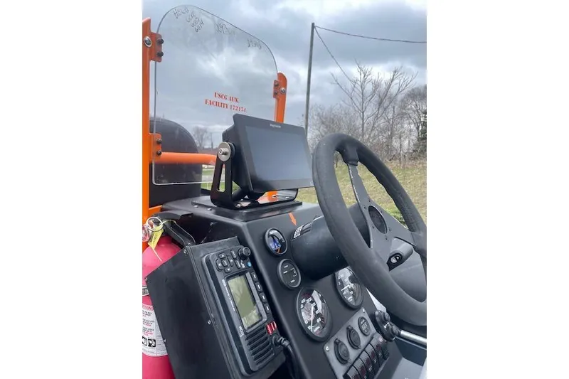 Slide: The Image of Control panel of a 1997 Zodiac boat with steering wheel and navigation equipment. - 12