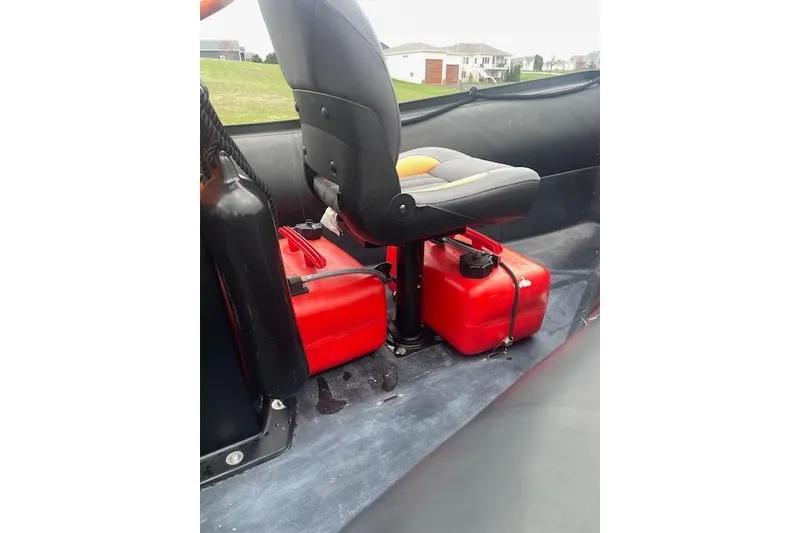 Slide: The Image of Interior of a 1997 Zodiac boat with seat and red fuel containers. - 14
