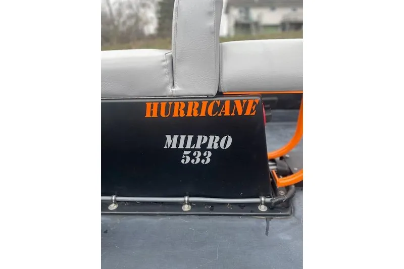 Slide: The Image of Zodiac Hurricane MILPRO 533 boat seat, 1997 model, with orange and black design. - 16