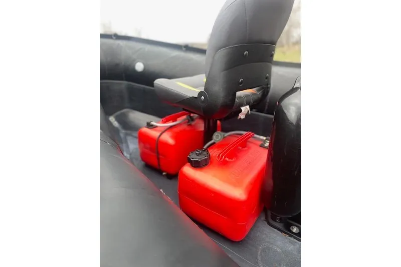 Slide: The Image of Interior of a 1997 Zodiac boat with red fuel containers and seating. - 18