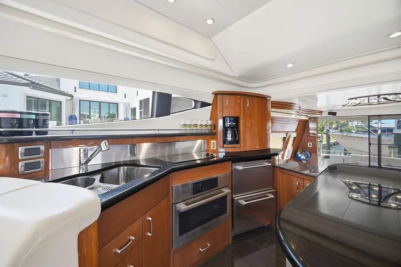 Slide: The Image of Luxurious 2006 Marquis 59 yacht kitchen with modern appliances and sleek wood cabinetry. - 13