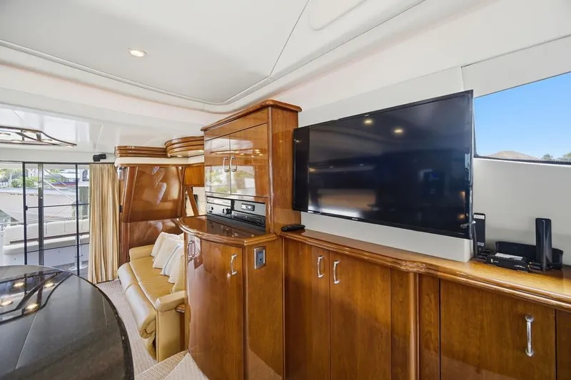Slide: The Image of Luxurious interior of a 2006 Marquis 59 yacht featuring elegant wood cabinetry and a large TV. - 15
