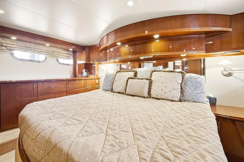 Slide: The Image of Luxurious bedroom interior of 2006 Marquis 59 yacht with elegant wood finishes and plush bedding. - 23