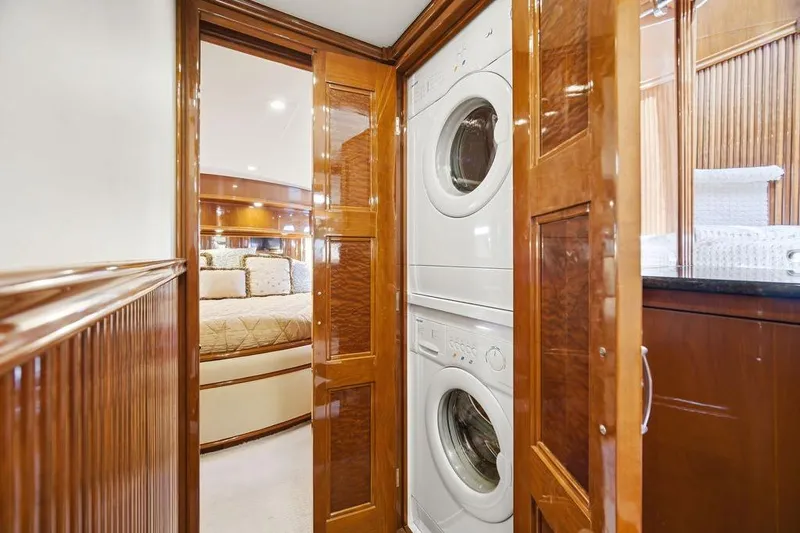 Slide: The Image of Luxurious 2006 Marquis 59 yacht interior with stacked washer and dryer in wooden cabinetry. - 27