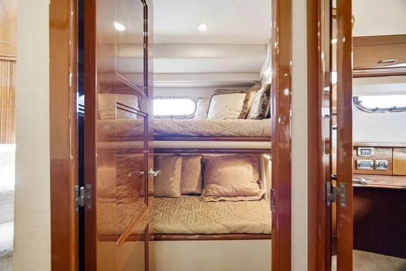 Slide: The Image of Luxurious 2006 Marquis 59 yacht interior with cozy bunk beds and elegant wood finish. - 28