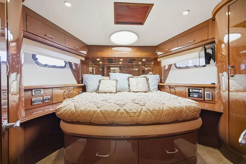 Slide: The Image of Luxurious 2006 Marquis 59 yacht bedroom with elegant wood finish and plush bedding. - 29