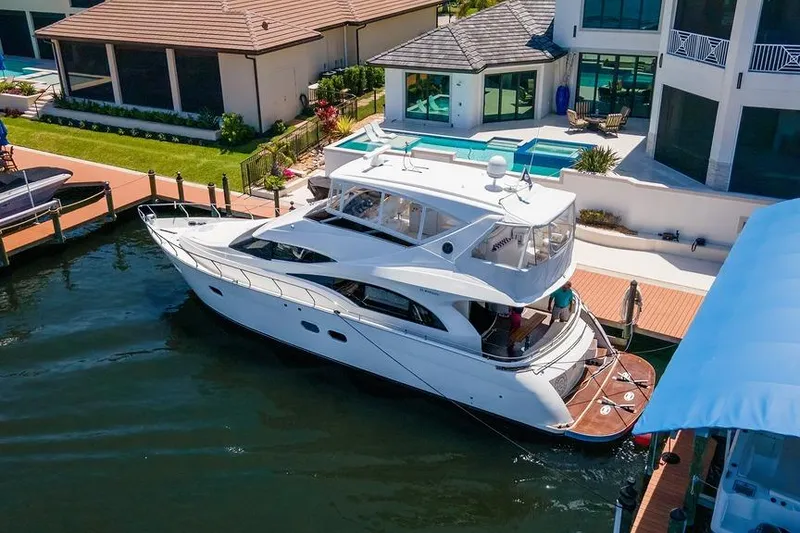 Slide: The Image of Luxury 2006 Marquis 59 yacht docked beside waterfront home with pool. - 3