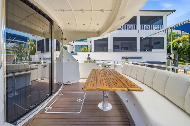 Slide: The Image of Luxurious 2006 Marquis 59 yacht deck with elegant seating and wooden table. - 32