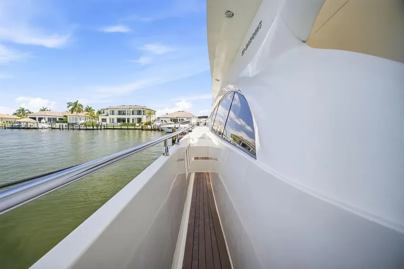 Slide: The Image of Side view of a 2006 Marquis 59 yacht with waterfront homes in the background. - 33