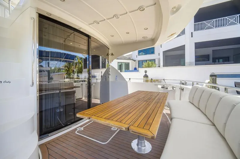 Slide: The Image of Luxurious 2006 Marquis 59 yacht deck with elegant seating and wooden table. - 34