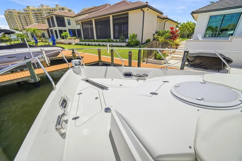 Slide: The Image of Luxury yacht Marquis 59 (2006) docked near waterfront homes and lush landscaping. - 35