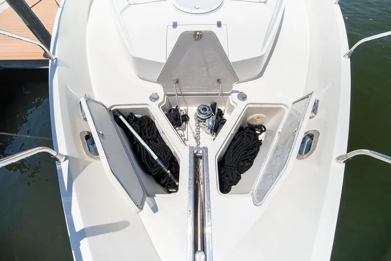 Slide: The Image of Bow storage compartments on a 2006 Marquis 59 yacht, featuring ropes and anchor equipment. - 36