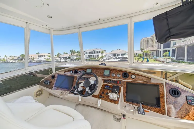 Slide: The Image of Luxurious 2006 Marquis 59 yacht cockpit with modern navigation systems and waterfront view. - 44