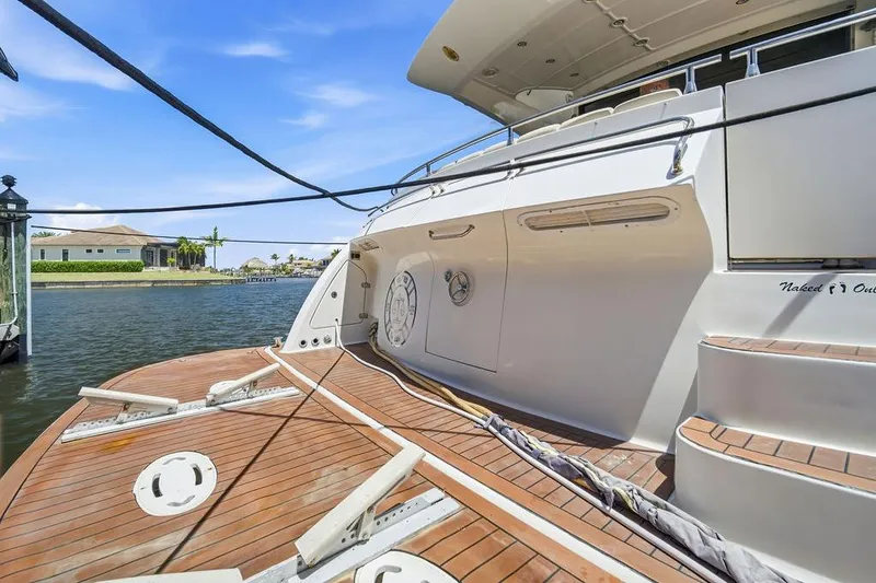 Slide: The Image of Luxury 2006 Marquis 59 yacht docked, featuring elegant wooden deck and sleek design. - 46