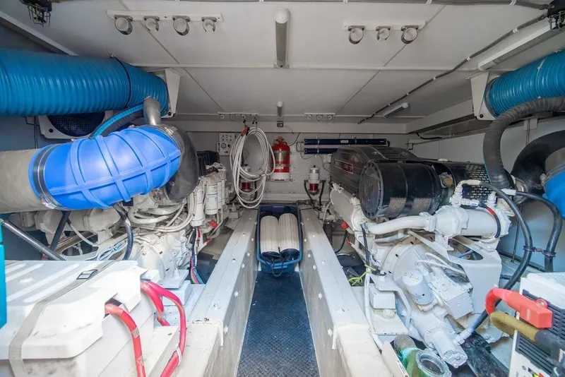 Slide: The Image of Engine room of a 2006 Marquis 59 yacht, featuring dual engines and blue ventilation ducts. - 47