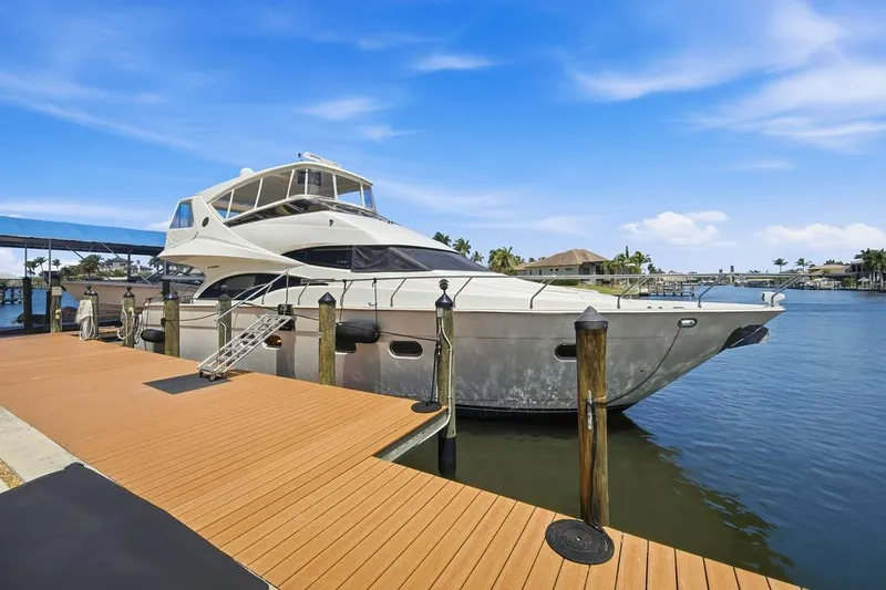 Slide: The Image of Luxury 2006 Marquis 59 yacht docked at marina under clear blue sky. - 5