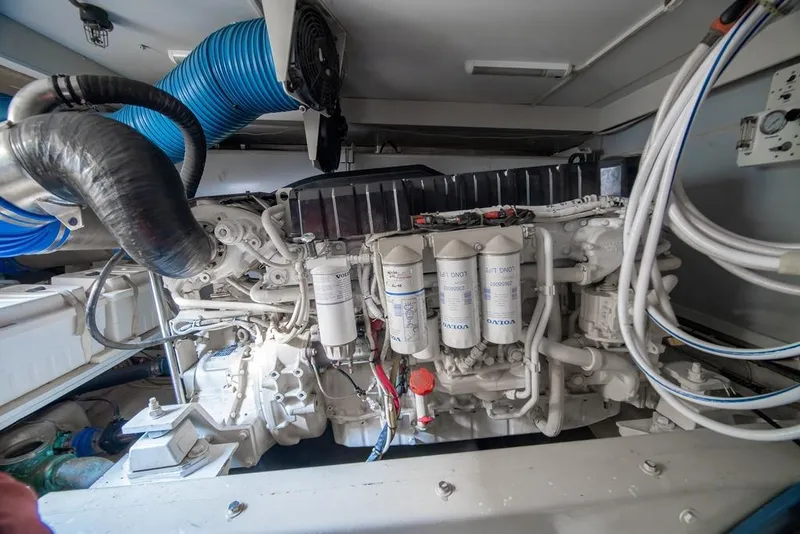 Slide: The Image of Engine compartment of a 2006 Marquis 59 yacht, featuring Volvo components and blue ventilation hose. - 56