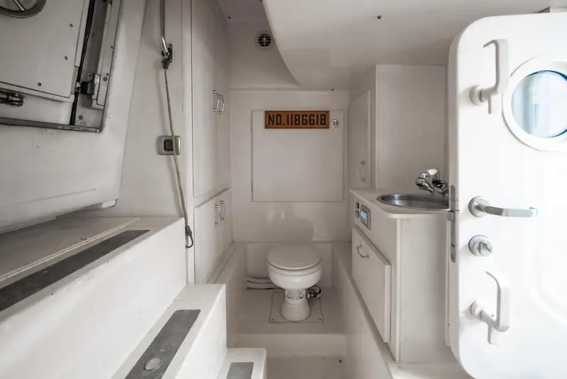 Slide: The Image of Compact bathroom in 2006 Marquis 59 yacht with toilet, sink, and storage cabinets. - 58