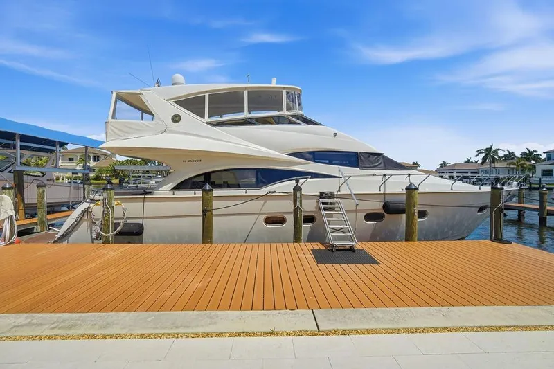 Slide: The Image of Luxury 2006 Marquis 59 yacht docked at marina under clear blue sky. - 6
