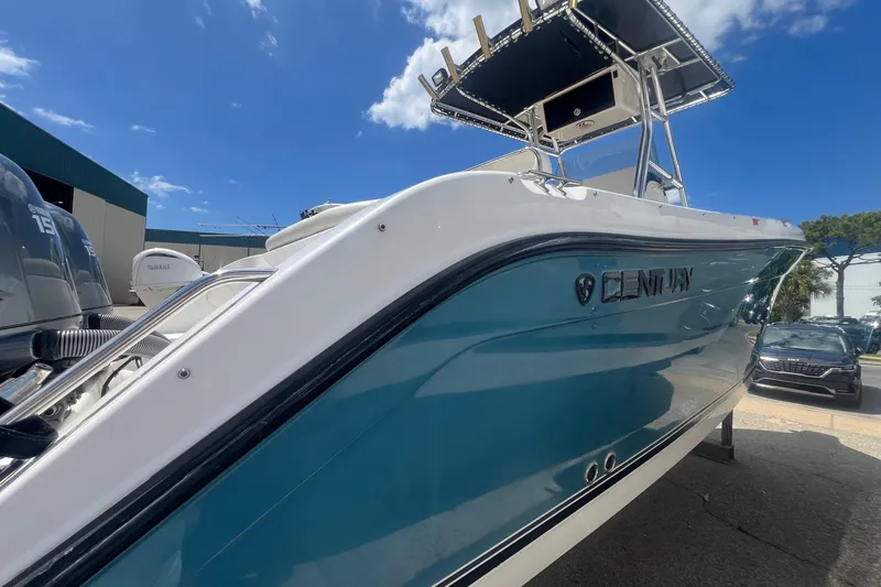 Slide: The Image of 2007 Century 2400 Center Console boat with blue hull, parked outdoors under a clear sky. - 14