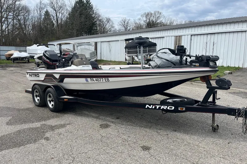 The Image of 1999 Nitro 896 Savage boat on trailer, parked outdoors near storage units. - 1