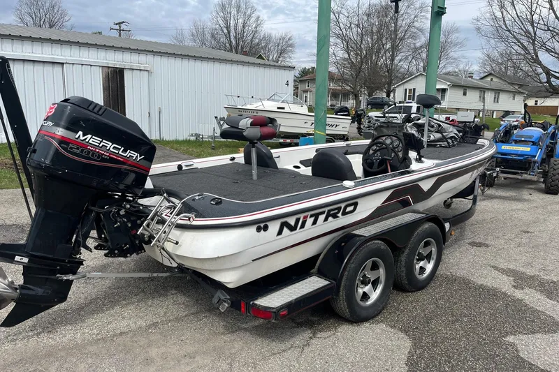 Slide: The Image of 1999 Nitro 896 Savage boat with Mercury engine on trailer, parked outdoors. - 3