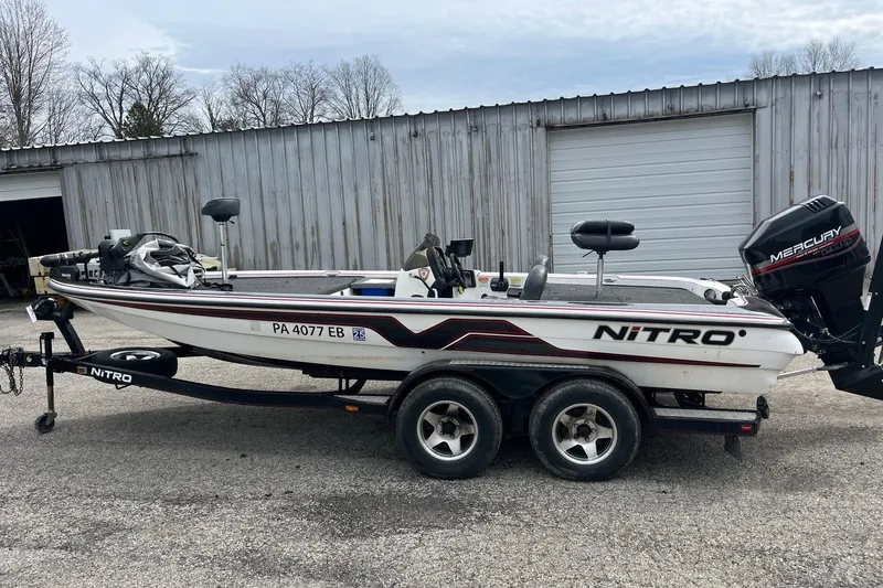 Slide: The Image of 1999 Nitro 896 Savage boat on trailer, parked near a metal building. - 5