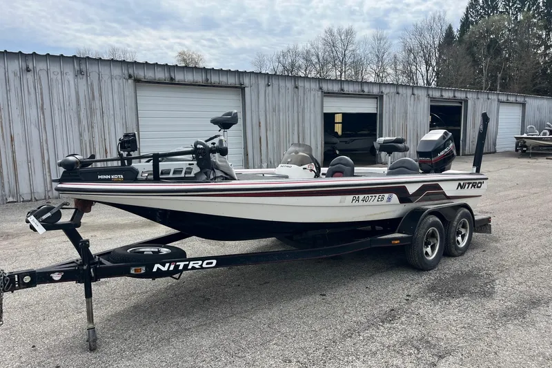 Slide: The Image of 1999 Nitro 896 Savage boat on trailer, parked outside metal storage units. - 6