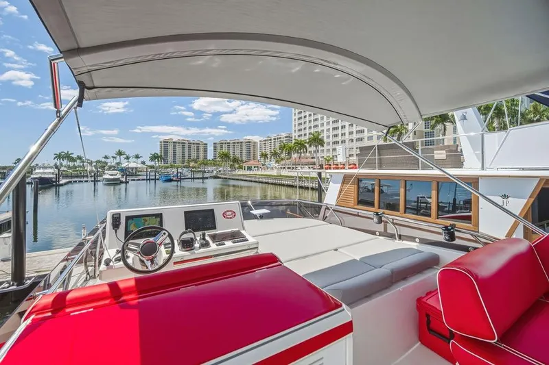 Slide: The Image of Luxurious 2024 Prestige 520 yacht interior with red seating, docked at a scenic marina. - 12