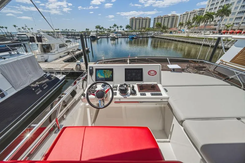 Slide: The Image of Helm of 2024 Prestige 520 yacht docked at a marina with luxury surroundings. - 14