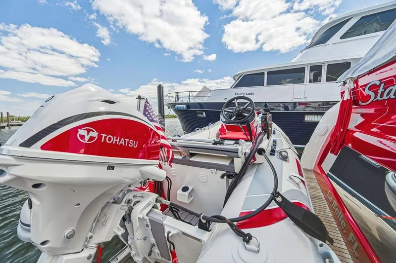 Slide: The Image of A 2024 Prestige 520 yacht docked, featuring a Tohatsu outboard motor and inflatable boat. - 17