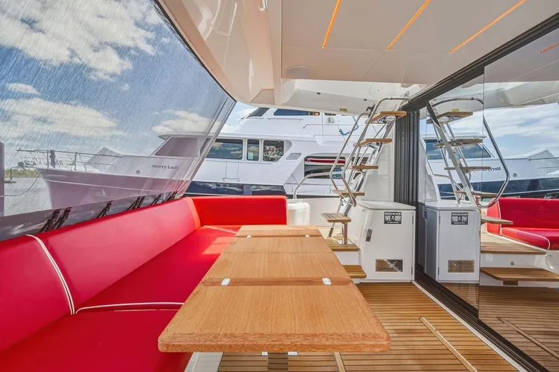 Slide: The Image of Luxurious 2024 Prestige 520 yacht interior with red seating, wooden table, and modern staircase. - 18