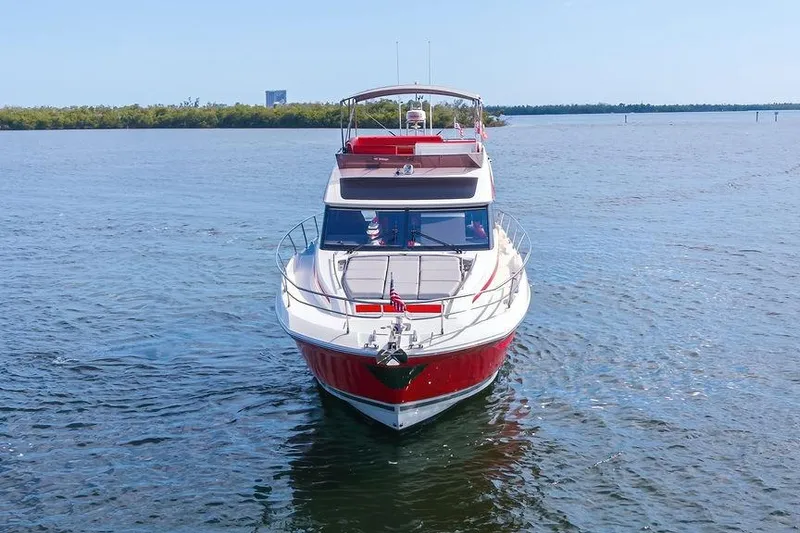 Slide: The Image of 2024 Prestige 520 yacht cruising on open water, showcasing sleek design and vibrant red accents. - 2