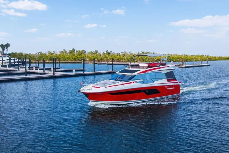 Slide: The Image of 2024 Prestige 520 yacht cruising on a sunny day near a marina. - 7