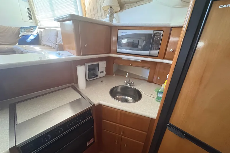 Slide: The Image of 2002 Carver 356 Aft Cabin Motor Yacht kitchen with microwave, sink, and stove. - 10
