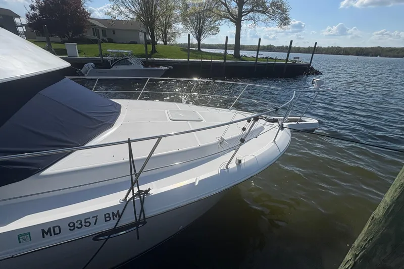 Slide: The Image of 2002 Carver 356 Aft Cabin Motor Yacht docked by a serene waterfront. - 3