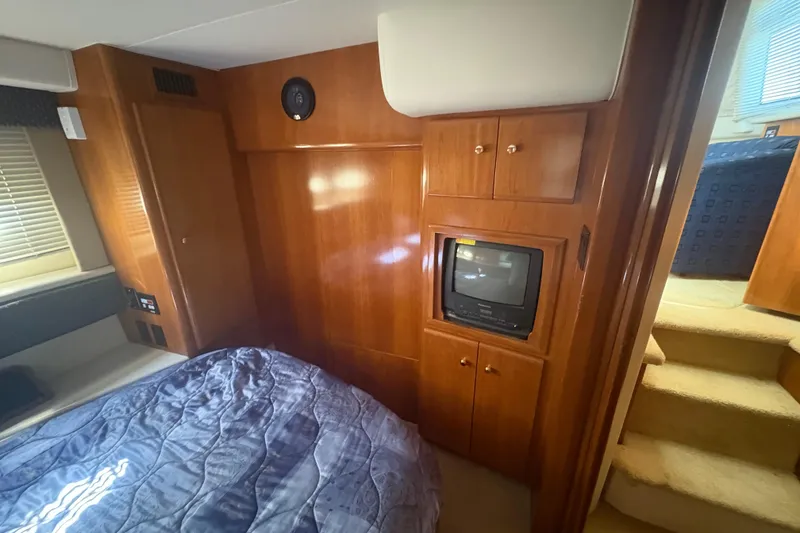 Slide: The Image of 2002 Carver 356 Aft Cabin Motor Yacht interior with wood cabinetry and built-in TV. - 8