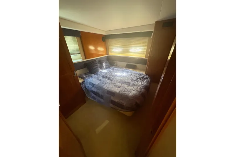 Slide: The Image of Cozy bedroom in 2002 Carver 356 Aft Cabin Motor Yacht with elegant bedding and wood accents. - 9