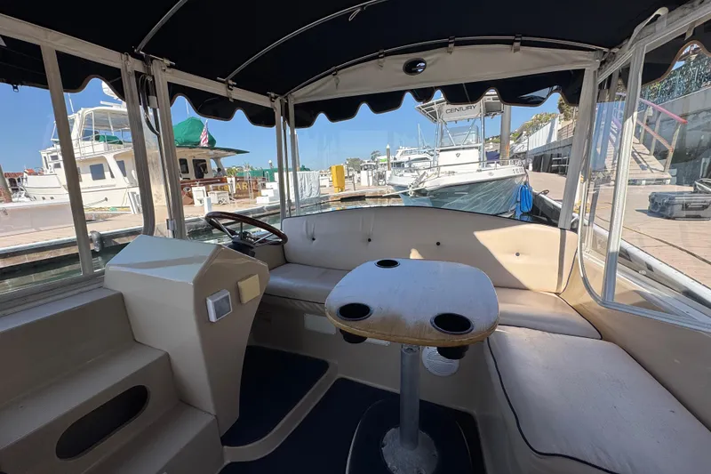 Slide: The Image of Interior of a 2008 Duffy Snug Harbor 18 boat with seating and table at a marina. - 6