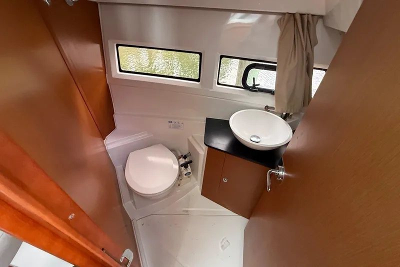 Slide: The Image of Compact bathroom in 2017 Jeanneau NC 895 boat with toilet, sink, and window. - 11