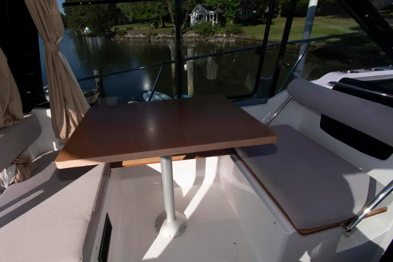 Slide: The Image of Interior of 2017 Jeanneau NC 895 boat with table and seating by the water. - 13