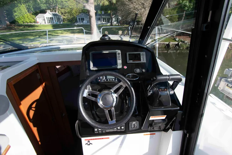 Slide: The Image of 2017 Jeanneau NC 895 helm with steering wheel and navigation controls. - 15